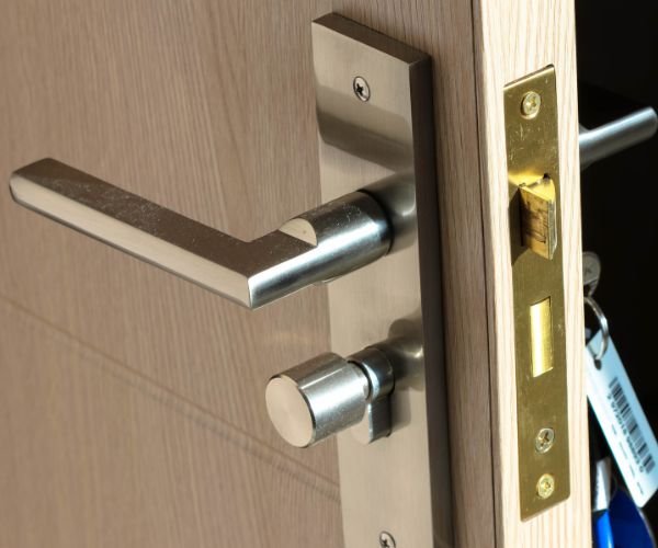 Locksmith replacing a door lock cylinder